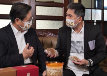 新竹縣長楊文科（左）拿起北埔膨風茶、擂茶、柿餅等客家美食，介紹在地必來景點、店家，也讓洪都拉斯的饕客雷達大響，直呼要來竹縣一趟深度旅遊! 圖/新竹縣政府